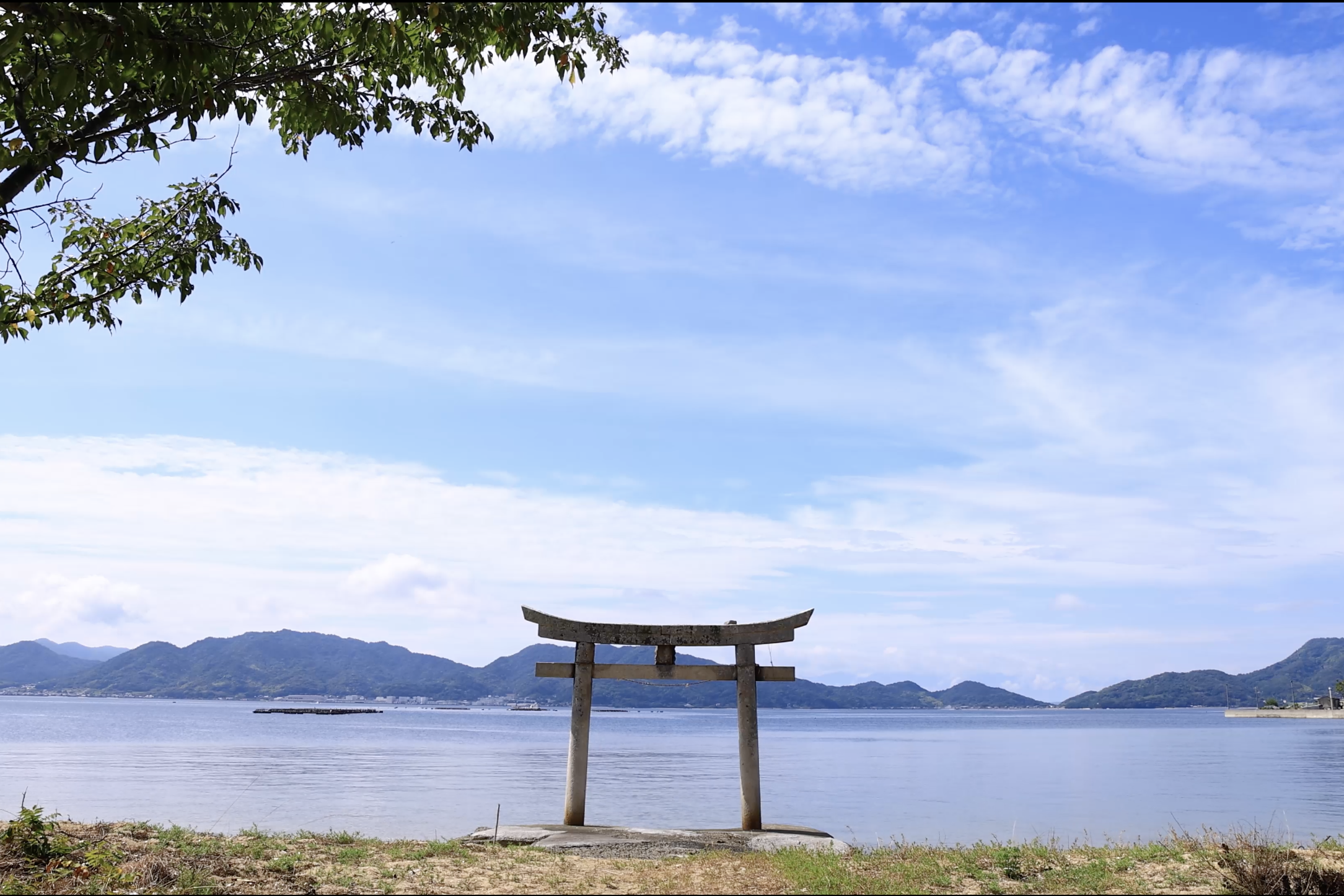 青空と海に輝く白い鳥居