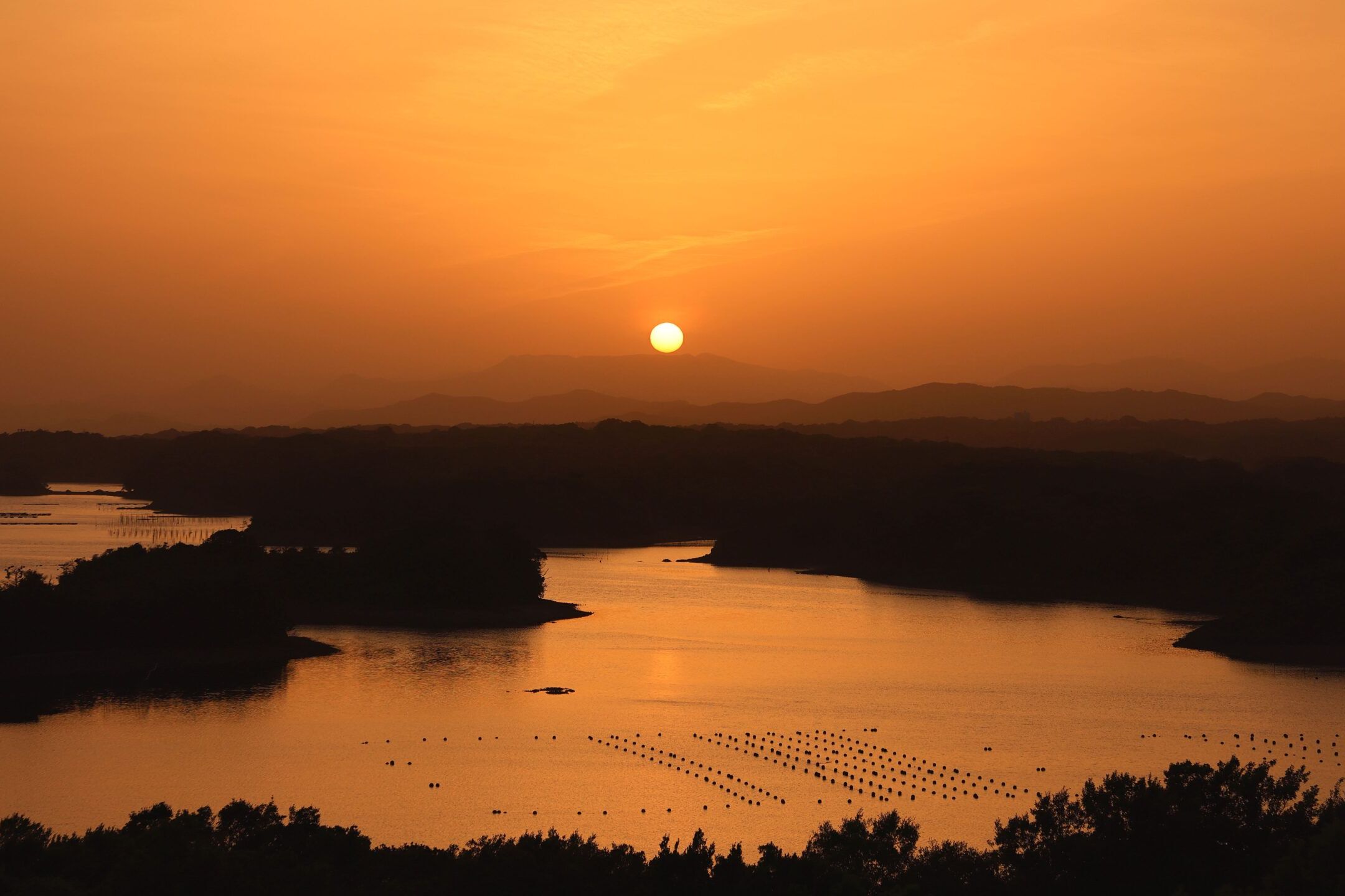 黄金色に輝く英虞湾の夕日と島影